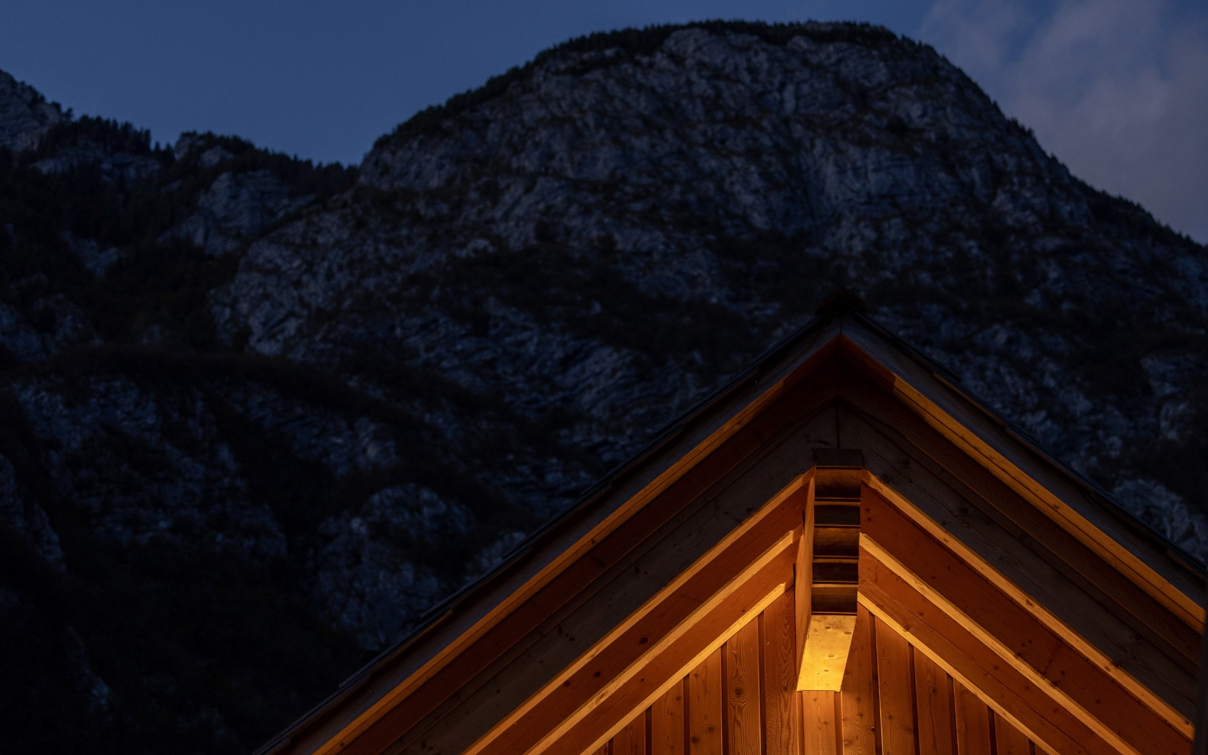 Detajl lesenega ostrešja novega alpskega Chalet-a pri Privillage Stare ob Bohinjskem jezeru v mraku.