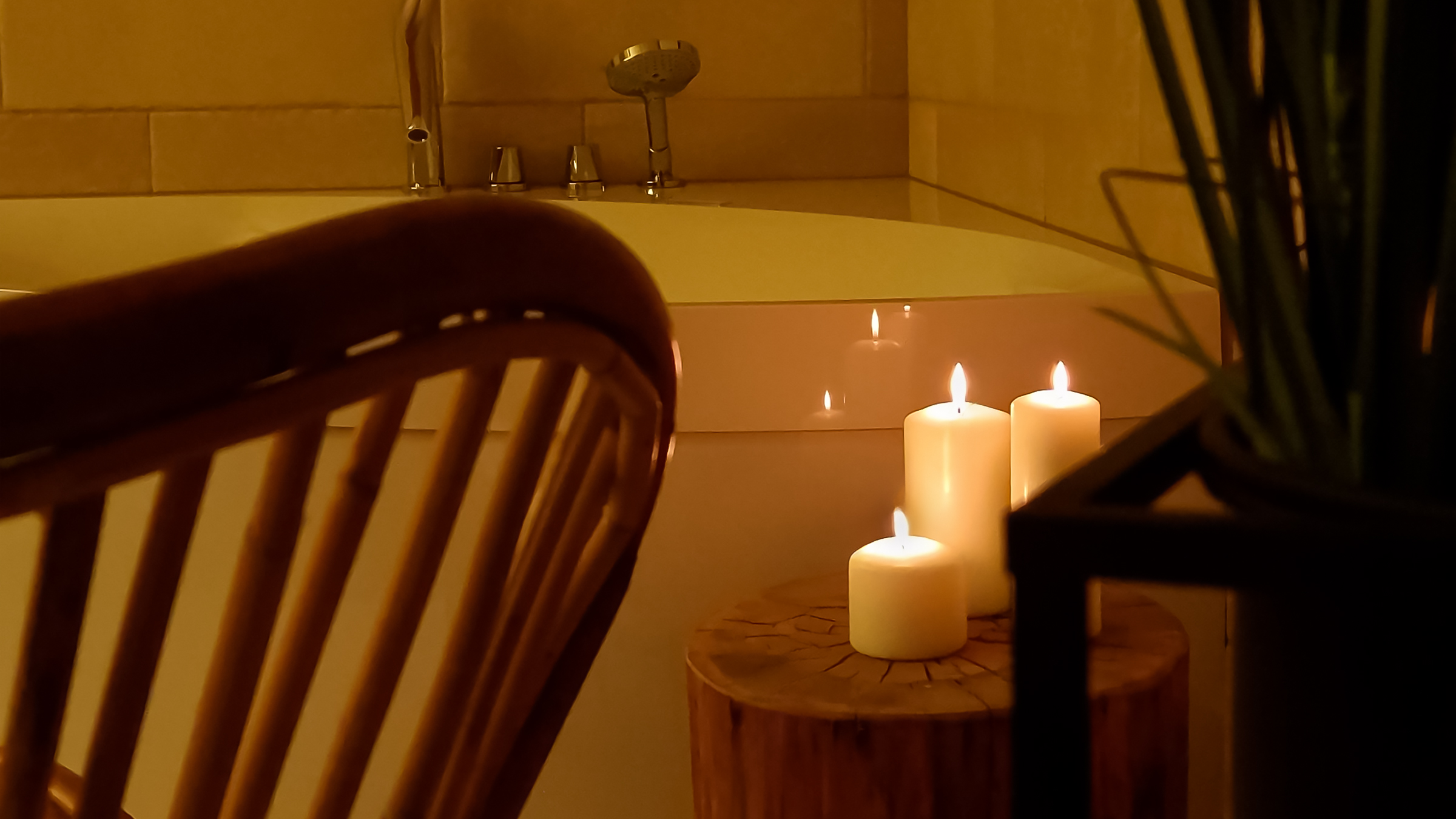 Sveče ob masažni kadi v zasebnem wellnessu Alpskega SPA Chaleta ob Bohinjskem jezeru.