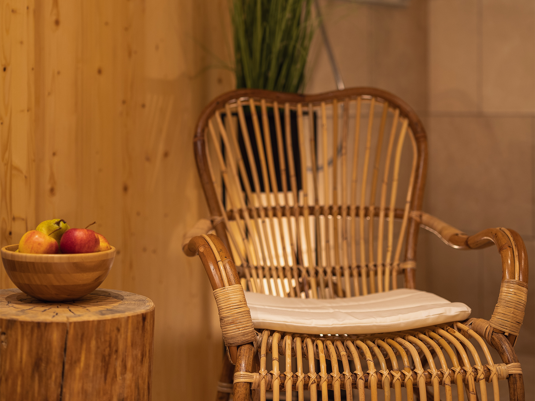 Ratan stol ob leseni mizici s svežim sadjem v zasebnem wellnessu Alpskega SPA Chaleta ob Bohinjskem jezeru.